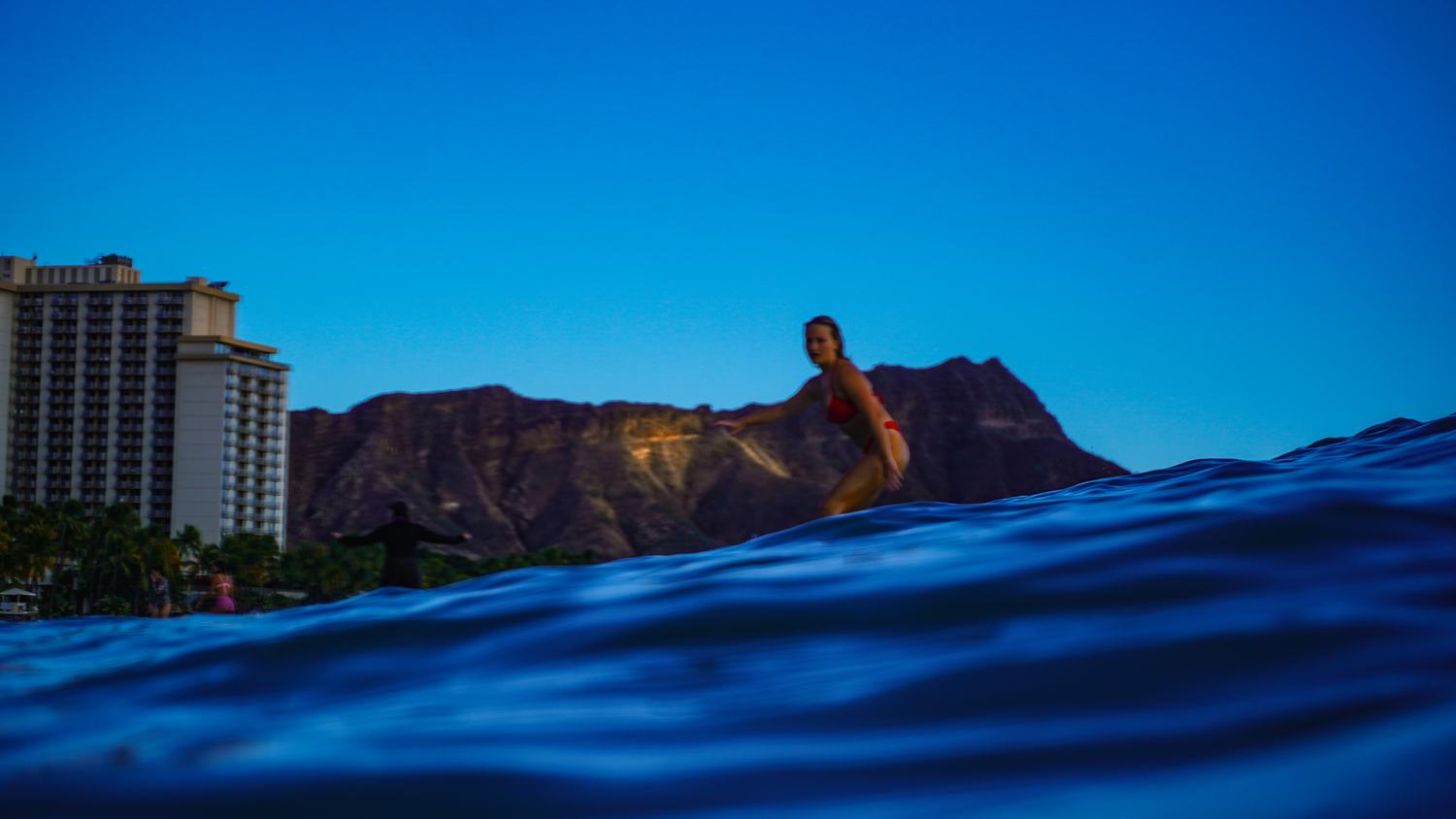 Silhouette of surfer against a dramatic dusk sky