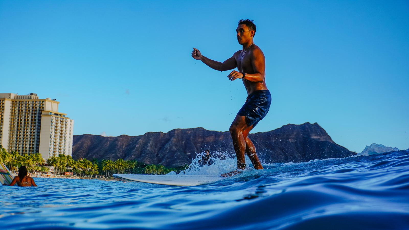 Woman surfing at sunset